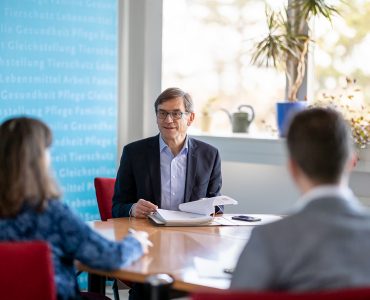 Ein Referatsleiter im TMASGFF in einer Besprechung mit 2 weiteren Mitarbeitenden