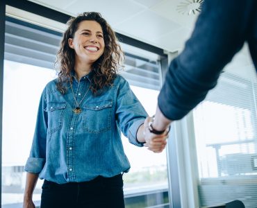 Eine lächelnde Frau schüttelt die Hand eines Mannes Copyright: ©Adobe Stock 430315416