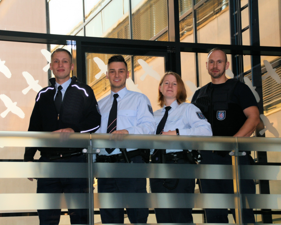 Vier Menschen in Uniform der Thüringer Justiz stehen zusammen an einem Treppengelaender Vier Menschen in Uniform der Thüringer Justiz stehen zusammen an einem Treppengelaender