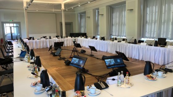 Ein Besprechungsraum mit technischem Equipment und gedeckten Tischen Ein Besprechungsraum mit technischem Equipment und gedeckten Tischen